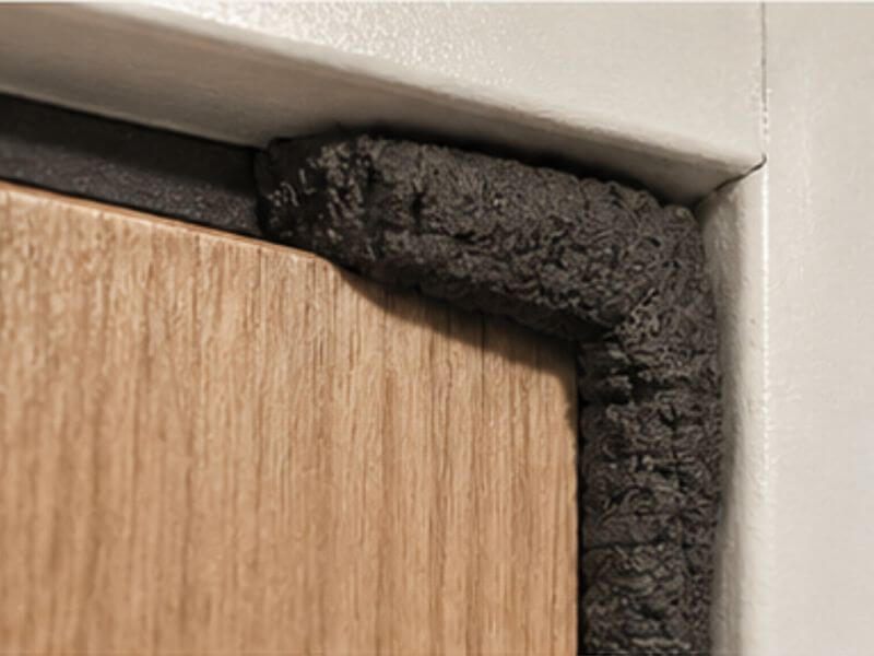 fire-rated-door-components-intumescent-seals - Holman, Inc. Fire rated door component showing expanded intumescent seal on fire rated door components blocking gap between door and frame